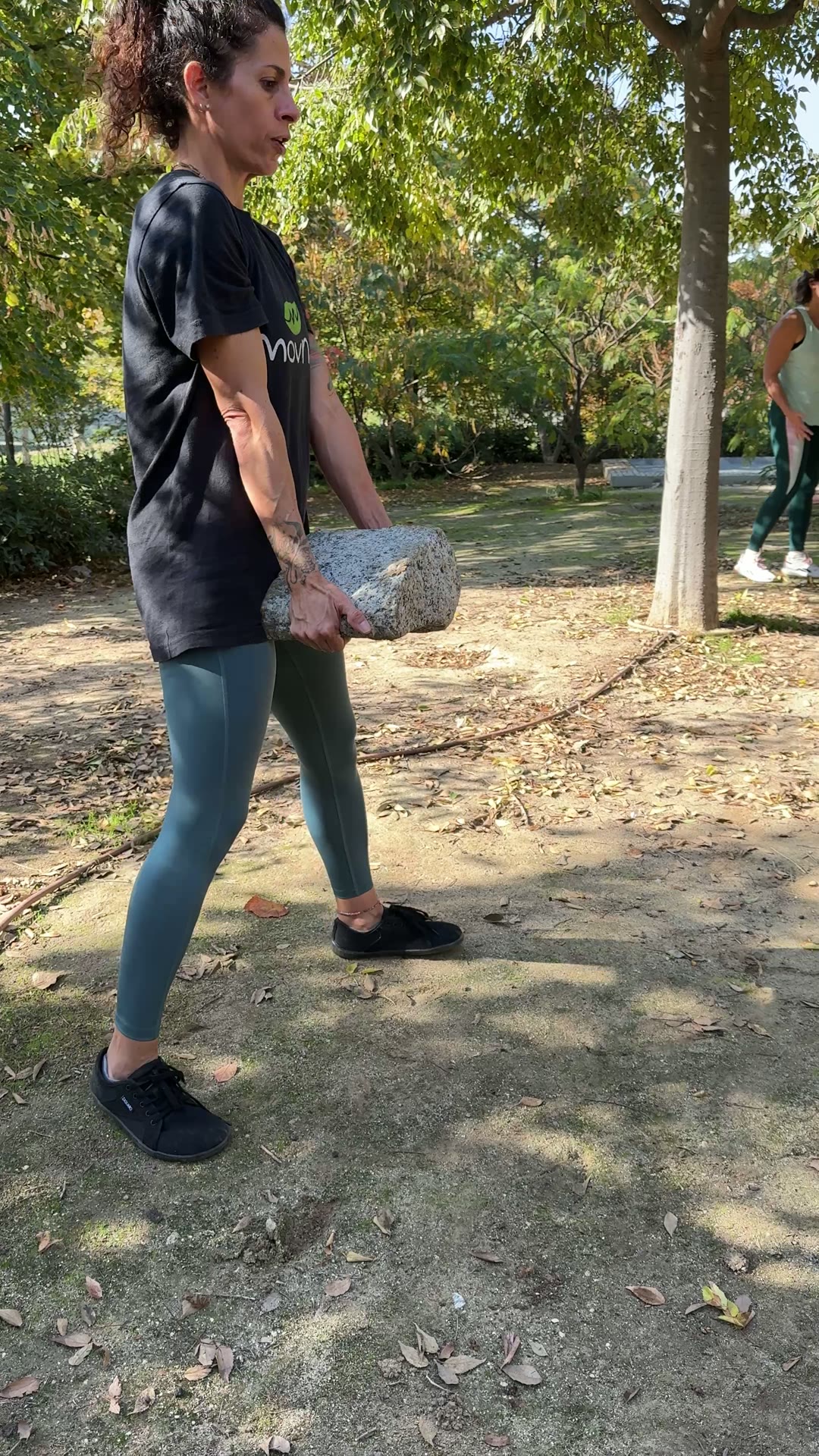 Alumna levantando una piedra del suelo en el parque