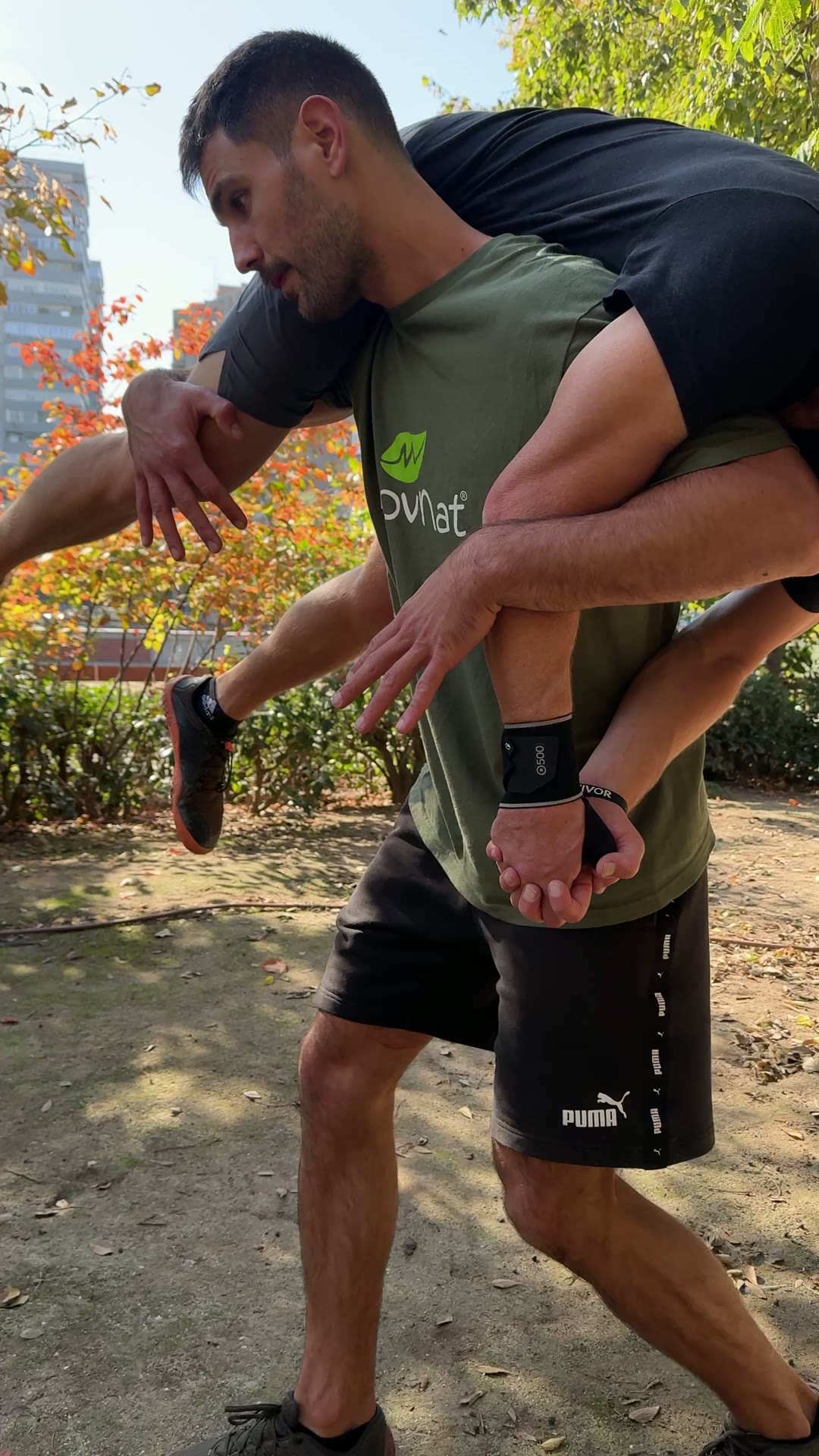 Alumno transportando a un compañero sobre los hombros en el parque
