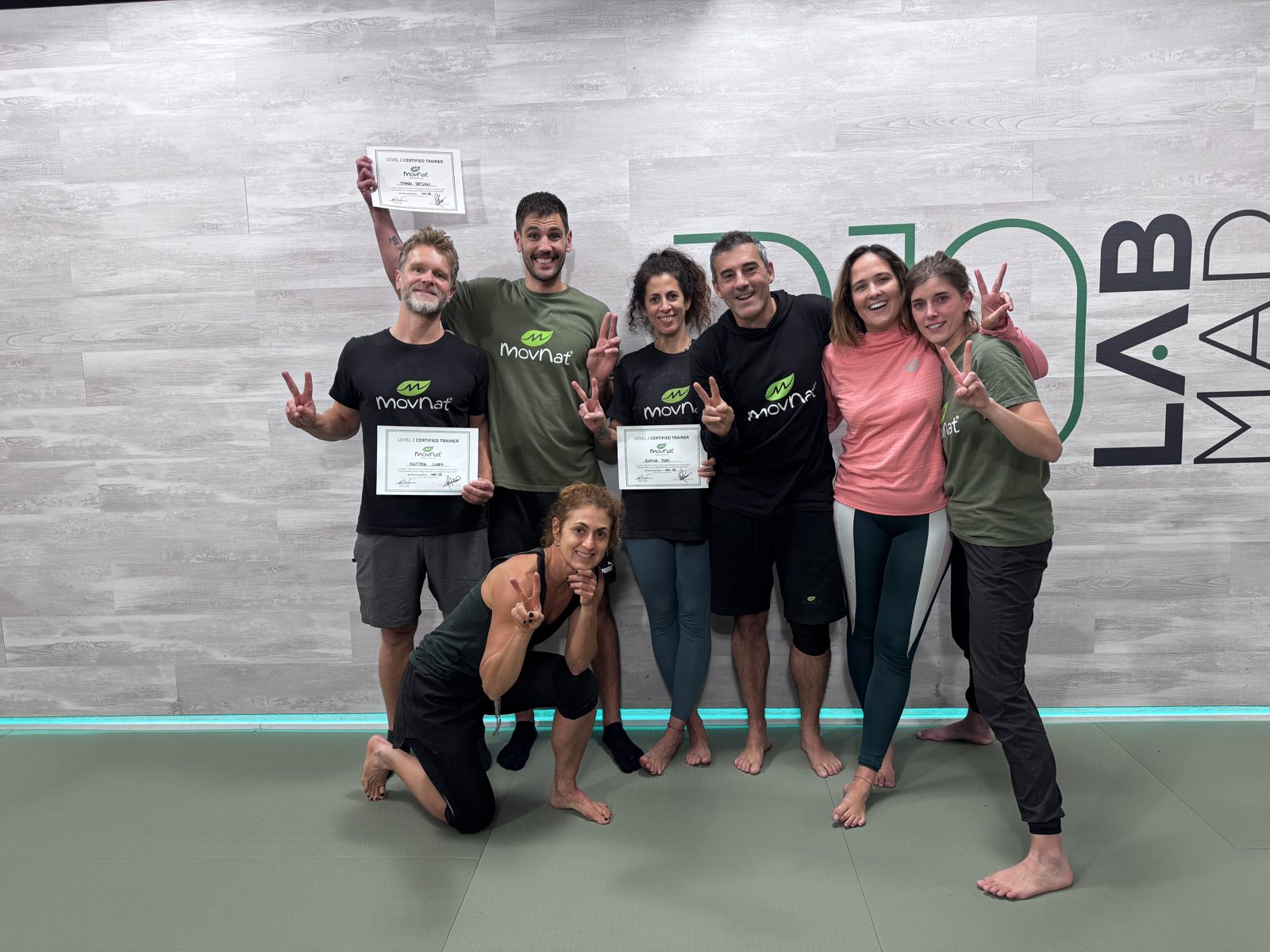 Grupo de alumnos e instructores con sus diplomas MovNat delante del mural R10LabMad